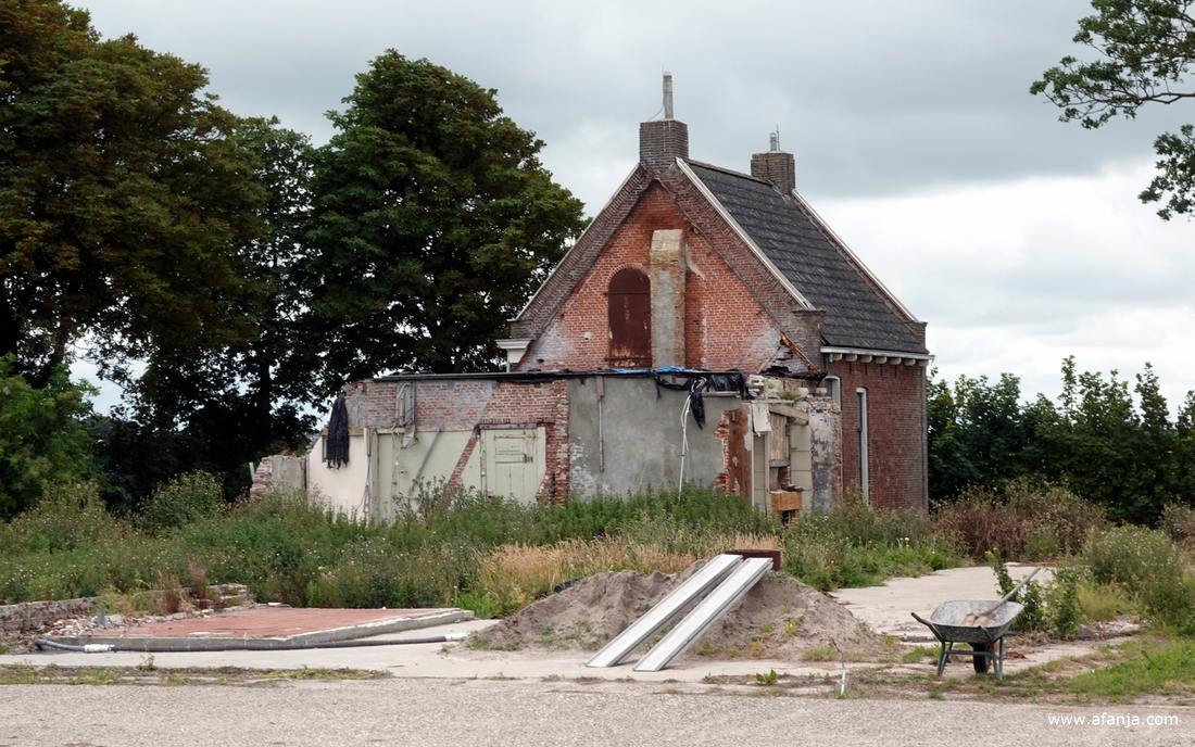 een afgebroken boerderij achter een dijkcoupure in de oude zeedijk