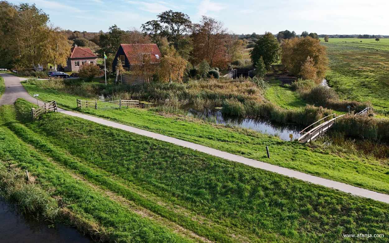 via een bruggetje kom je op een wandelpaadje langs een oude veensluis