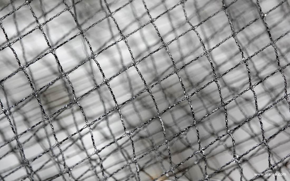 er hangt een net over de vijver om bladeren van de hazelaar op te vangen