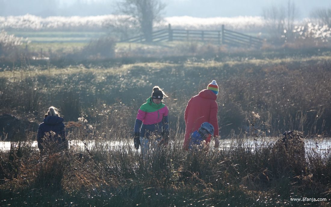 schaatsers in kleurige kleding hebben net hun schaatsen ondergebonden aan de kant