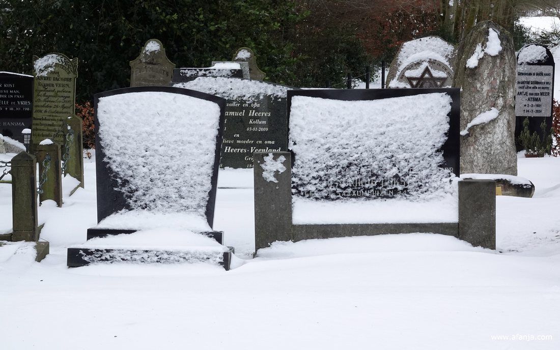 op de besneeuwde begraafplaats met de Groene toren in Eastermar-Heechsân