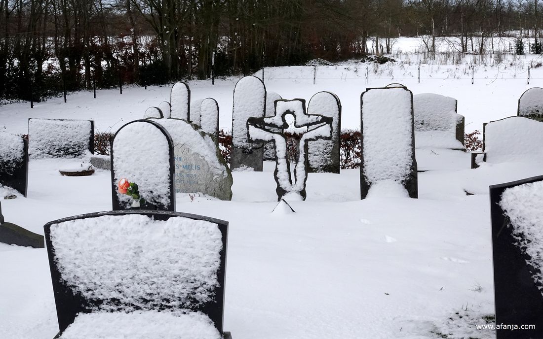 op de besneeuwde begraafplaats met de Groene toren in Eastermar-Heechsân