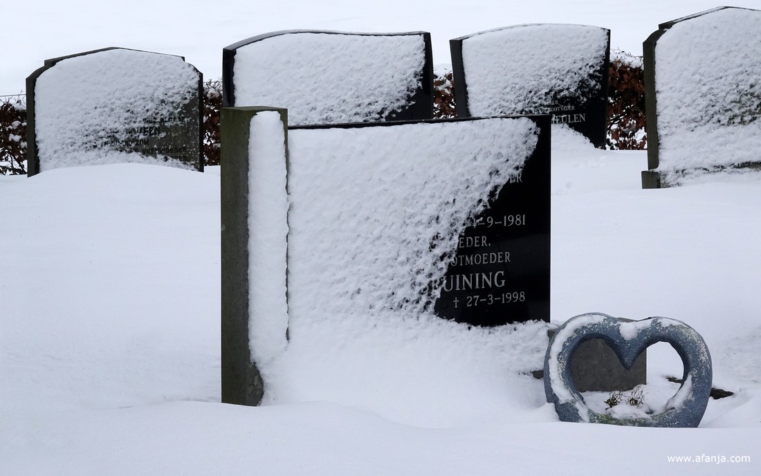 op de besneeuwde begraafplaats met de Groene toren in Eastermar-Heechsân
