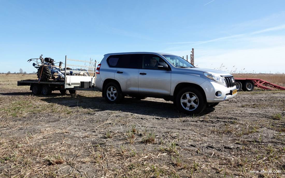 de auto van de rietsnijders met een aanhangwagen