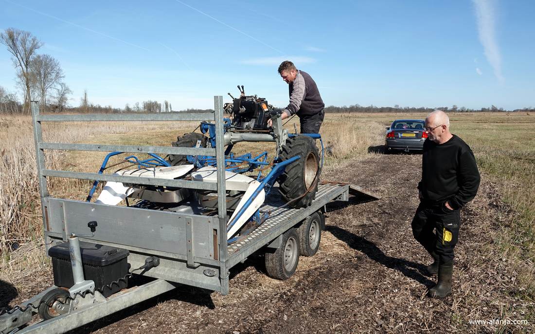 Klaas Jan maakt een rietmaaier op de aanhangwagen los