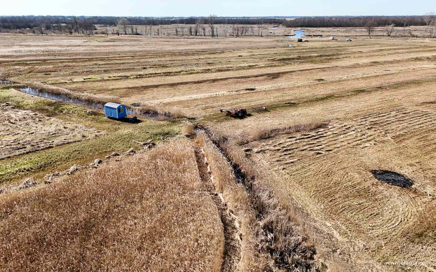 links-midden in het beeld de lichtblauwe schaftkeet, rechtsboven zijn de auto's nog te zien