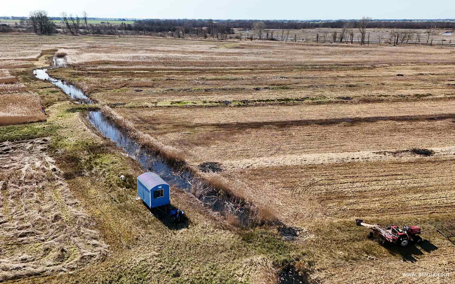 ik bestuur de drone vanuit de schaduw van de schaftkeet