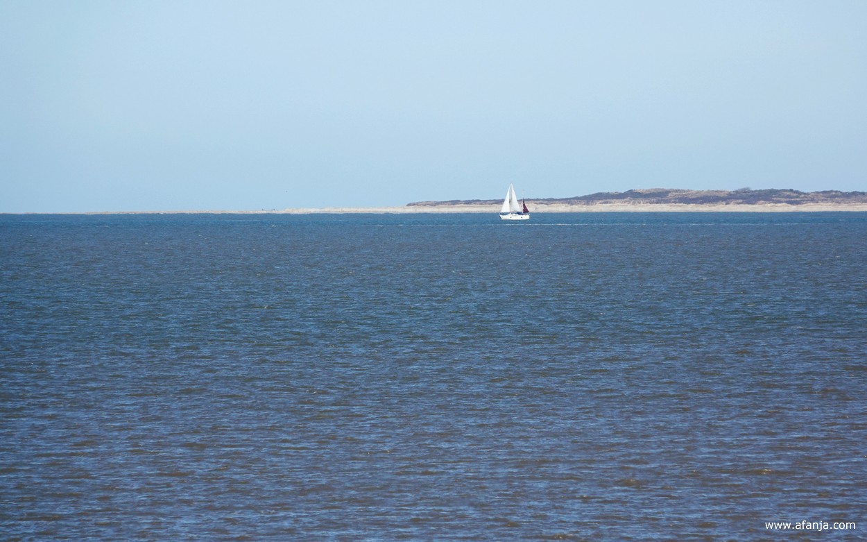 in de verte Schiermonnikoog en een zeilboot