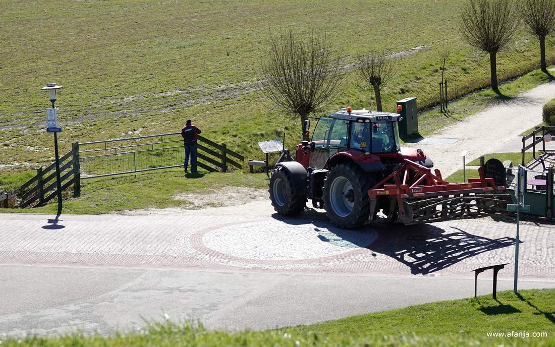 een boer heeft aan de Seewei zijn trekker verlaten om een hek te openen