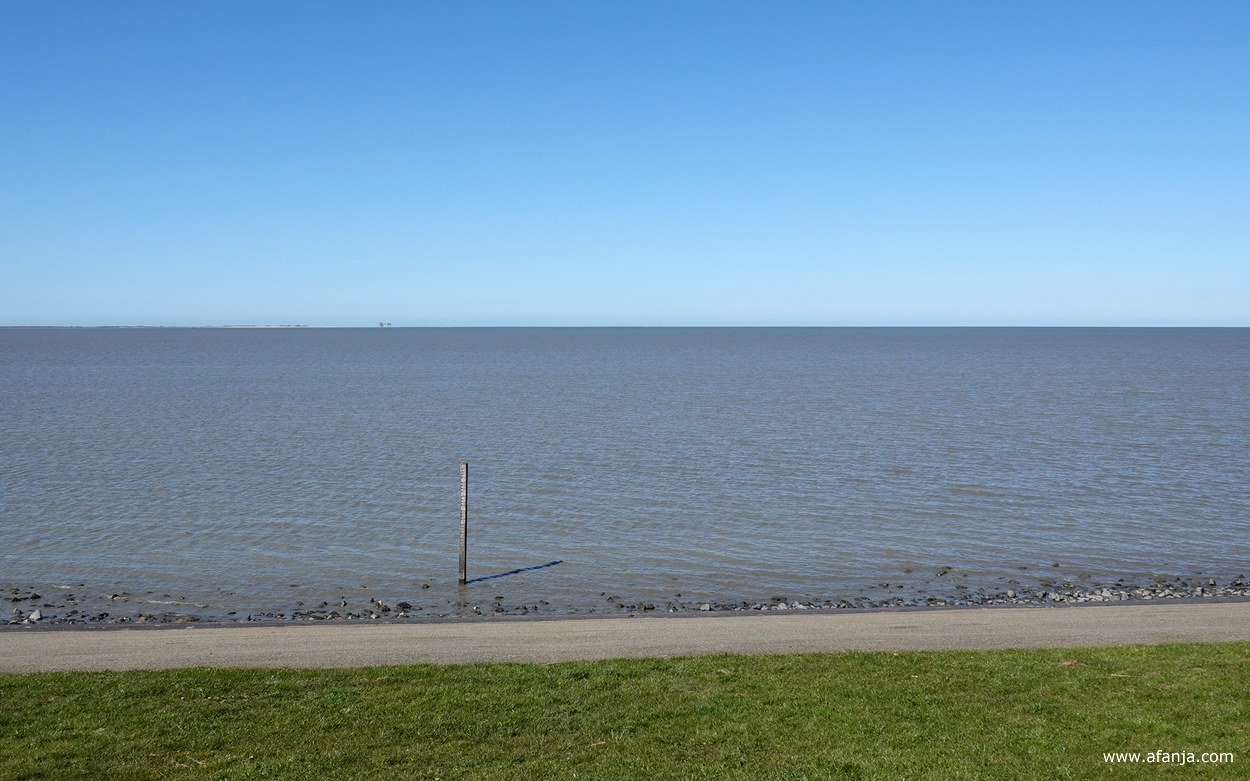 aan de voet van de dijk staat een oude peilschaal
