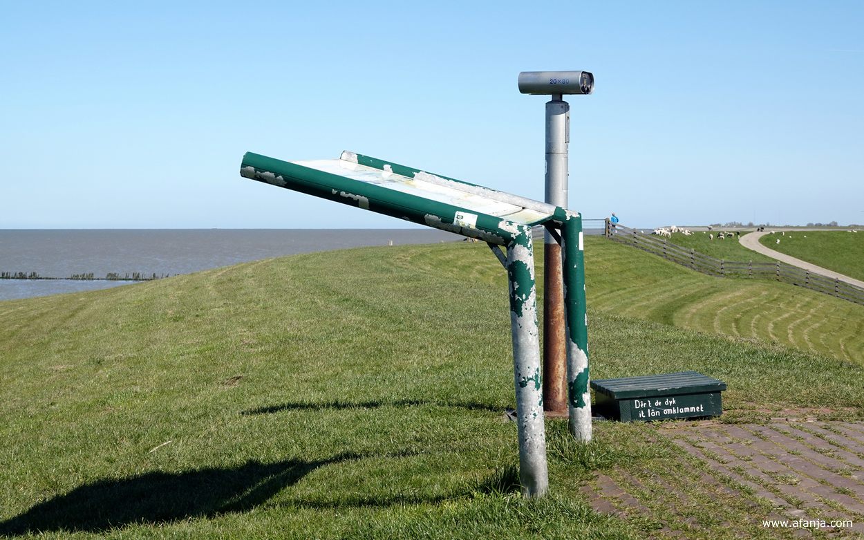 op de dijk bij Wierum staan een informatiepaneel en een verrekijker