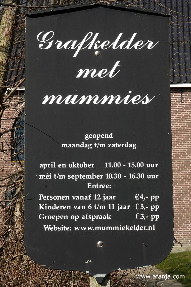 informatiebord met de toegangstijden tot de kerk en de grafkelder