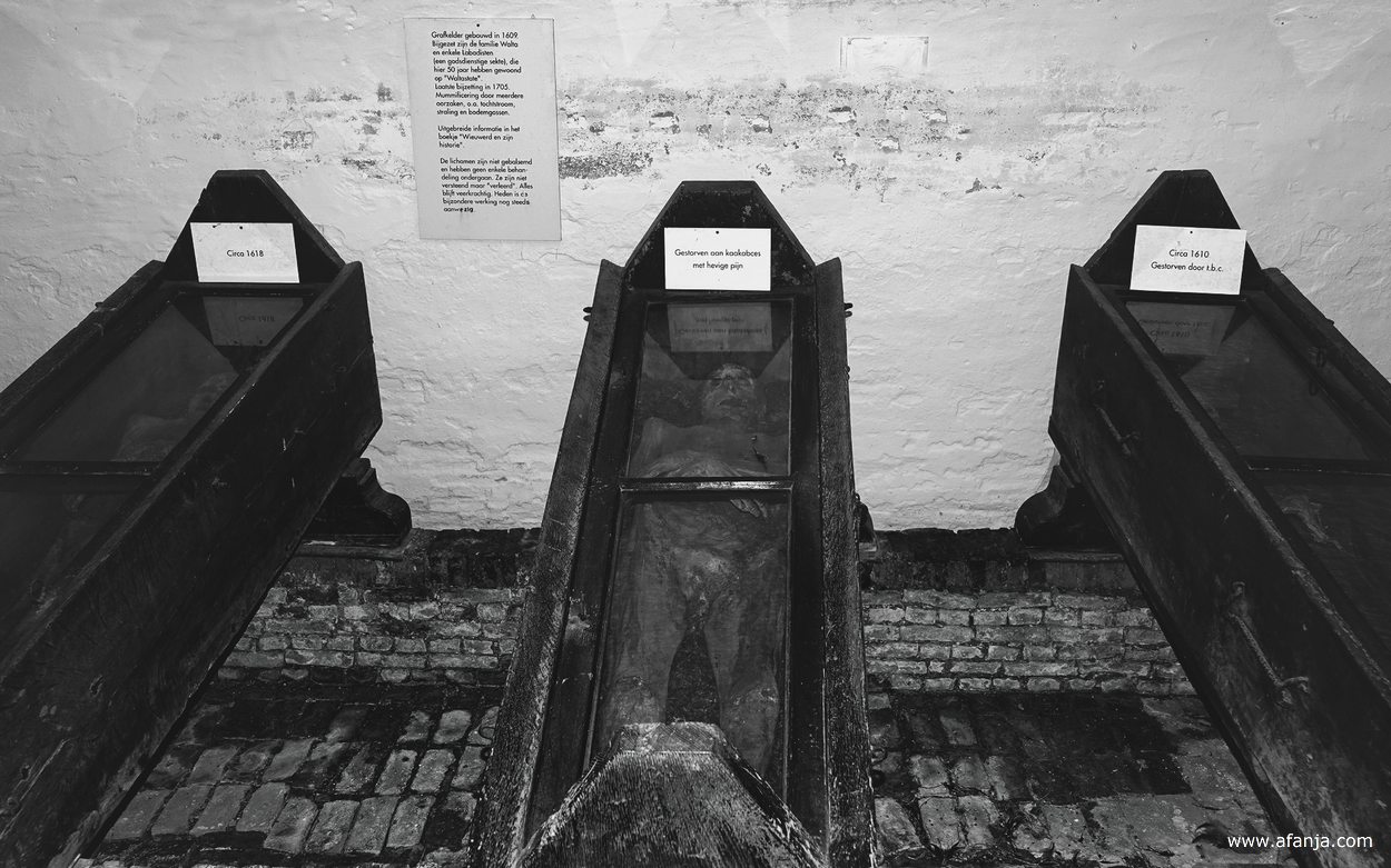 drie kisten met mummies in de grafkelder van de Nicolaaskerk in Wiuwert