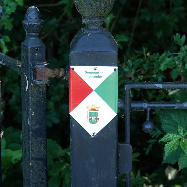op een paal van het hek staat dat het een gemeentelijk monument is