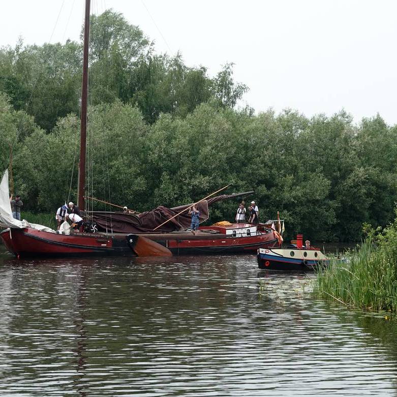 een skûtsje en een klein slepertje varen zij aan zij Buitenstvallaat binnen