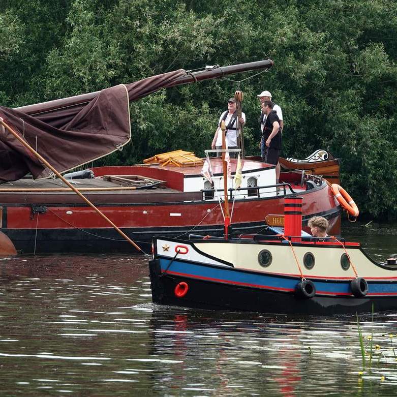 een skûtsje en een klein slepertje varen zij aan zij Buitenstvallaat binnen